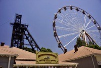 Modern ferris wheel next to historic mine headgear