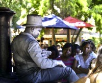 A silvered statue performer with an audience trying to see if he is real